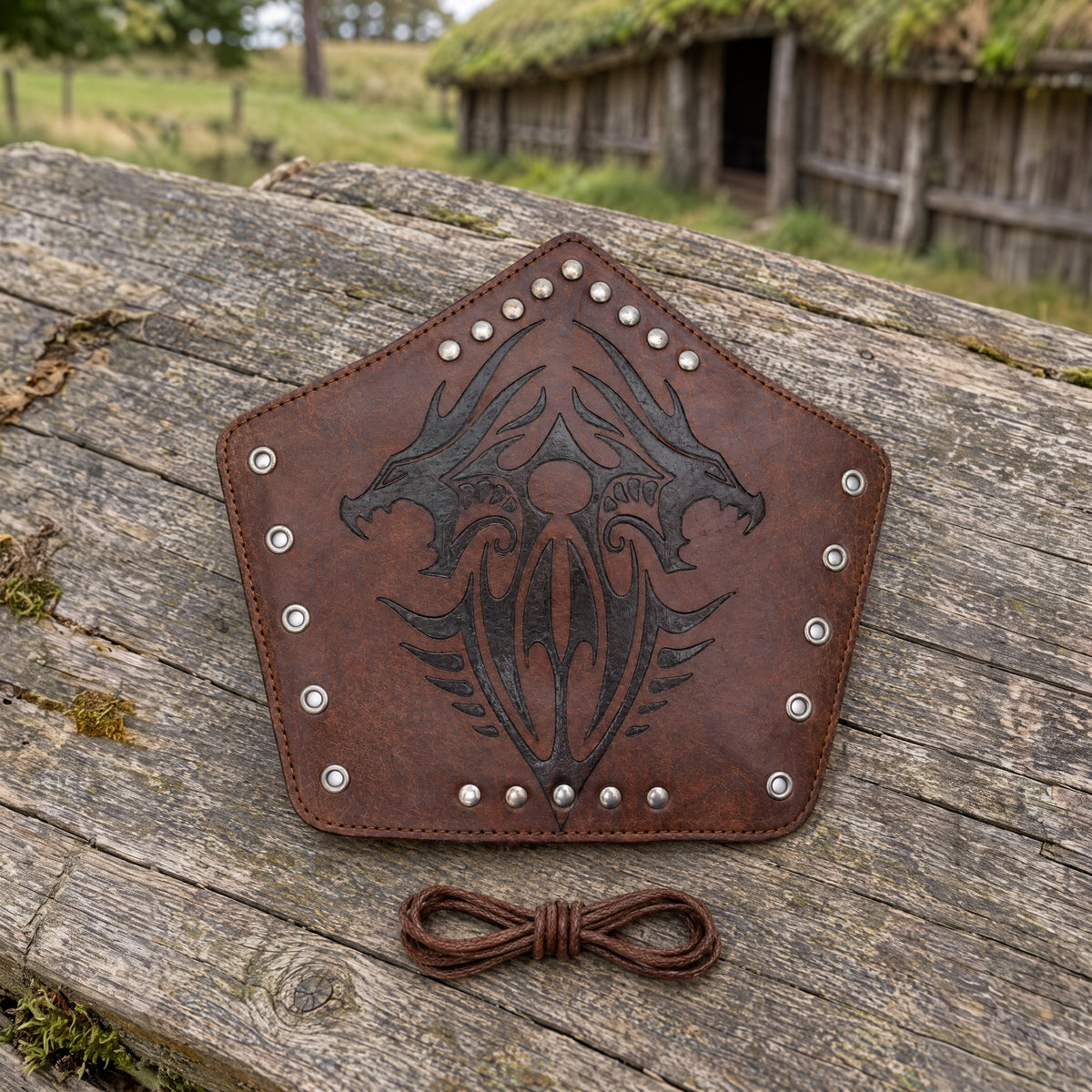 Brown twin dragon bracer on a rustic surface