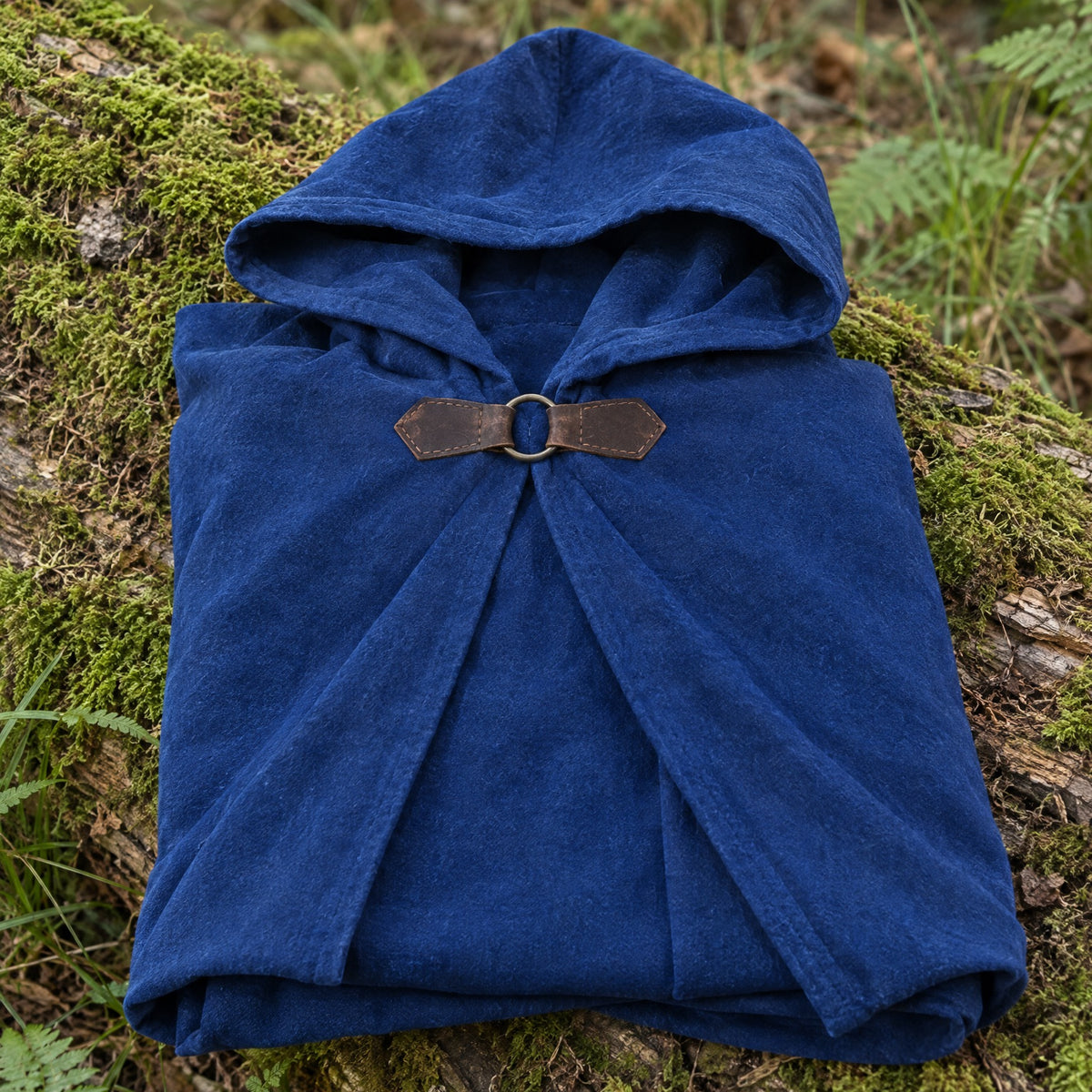 Blue velvet hooded cloak on a rustic surface