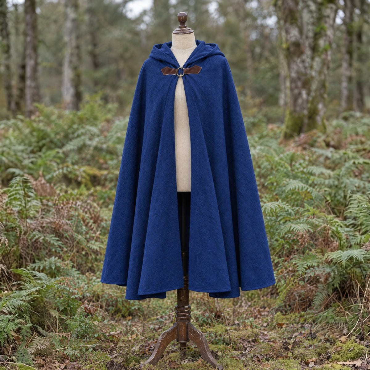 Blue velvet hooded cloak on a dress form outdoors