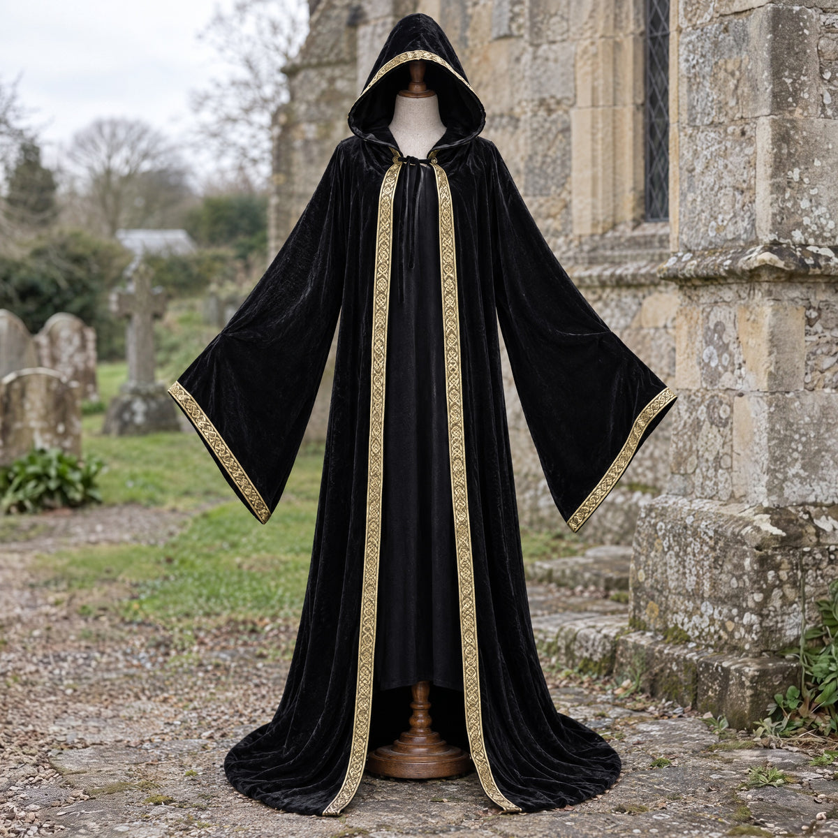 Black velvet hooded robe with printed trim on a dress form outdoors