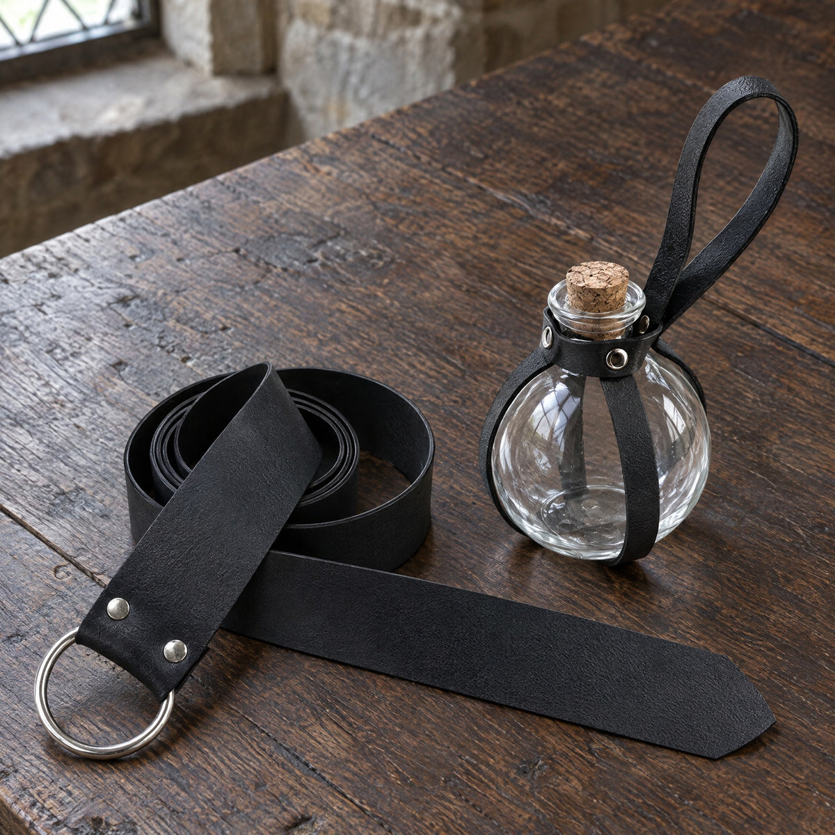 Black wide ring belt with bottle holder on a rustic surface