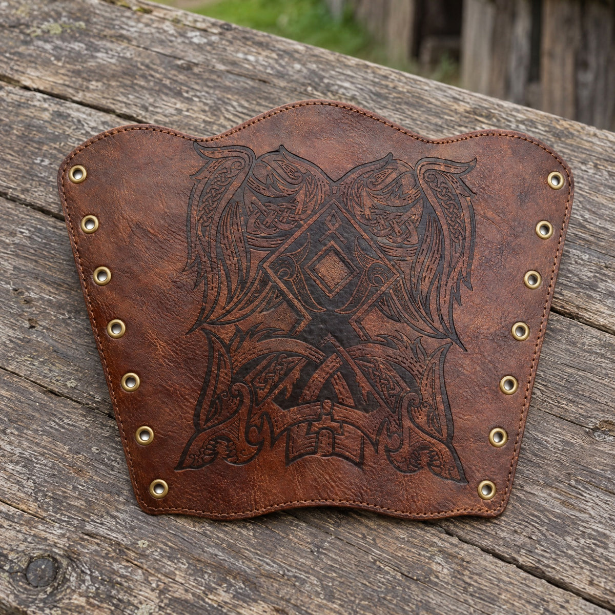 Brown winged beast rune bracer on a rustic surface